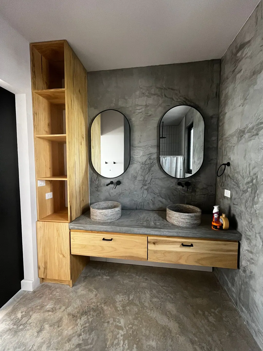 Baño con doble lavamanos, madera y paredes lujadas