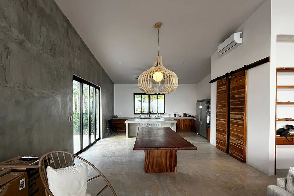Interior del tercer piso de una obra de JFB en Jacó: cocina, sala y comedor
