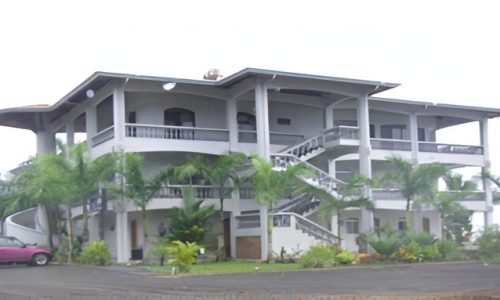 Edificio de tres niveles con balcones y escaleras exteriores en Costa Rica