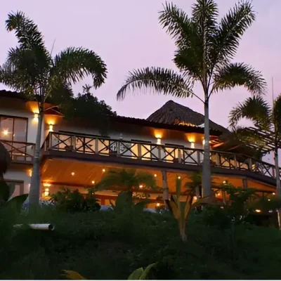 Facade of modern house with illuminated terraces and palm trees in Costa Rica