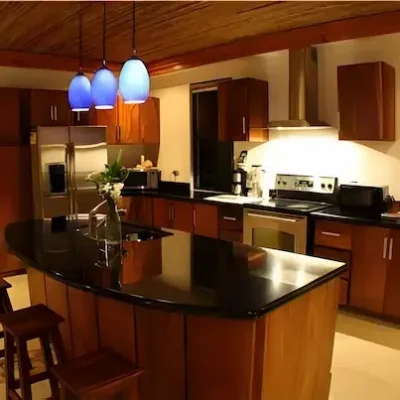 Modern kitchen with wooden cabinets and black granite countertop in Costa Rica