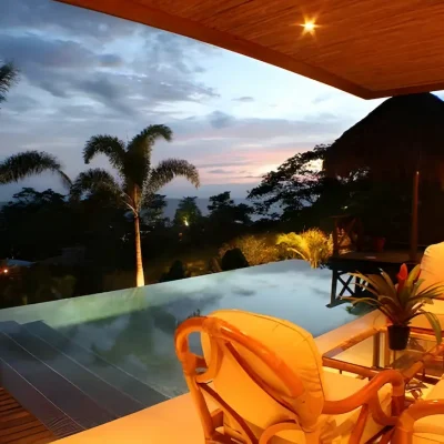 Infinity pool illuminated with ocean view at sunset in Costa Rica